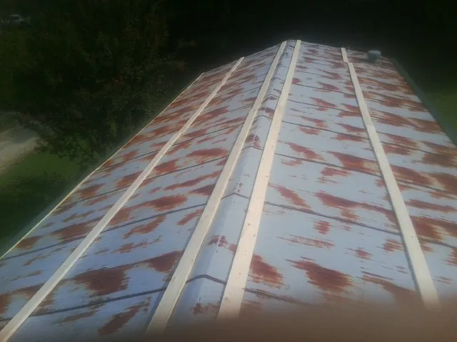 Rusted metal roof panels with new wood purlins before replacement — Storm Damage Roof Repair in Martell by Roofing Brothers